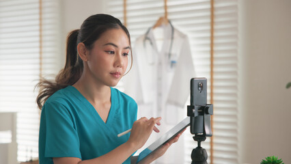 Young adult woman Gen Z asia people anti aging expert modern nurse live talk viral video selfie camera on mobile phone app mental health care. Online sharing digital virtual asian vlogger filming.