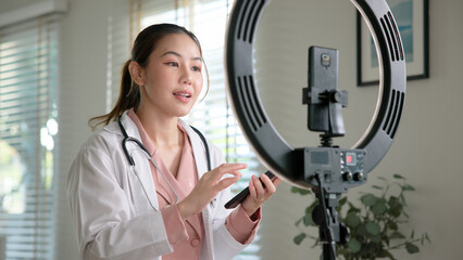 Young adult woman Gen Z asia people anti aging expert modern nurse live talk viral video selfie camera on mobile phone app mental health care. Online sharing digital virtual asian vlogger filming.
