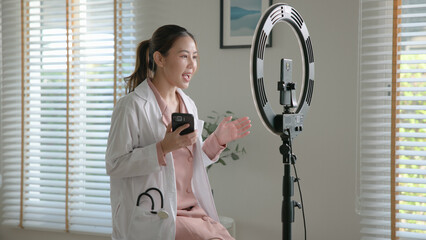 Young adult woman Gen Z asia people anti aging expert modern nurse live talk viral video selfie camera on mobile phone app mental health care. Online sharing digital virtual asian vlogger filming.