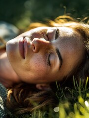 A woman lying on grass with eyes closed with sun rays touching their face