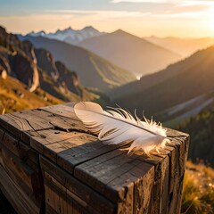 White feather rests on a wooden box, mountains & sunset in background