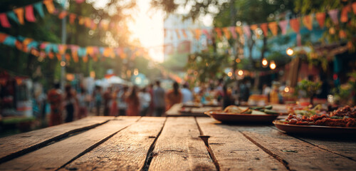 Fototapeta premium Outdoor street festival with colorful decorations, warm sunset lighting, lively crowd, and rustic wooden table with food displays