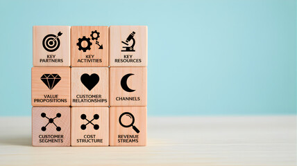 Stacked wooden blocks with symbols and text on a table against a blue background, representing concepts and ideas, captured from a straightforward viewpoint.