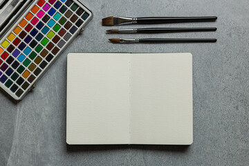 Watercolor Painting Workspace with Blank Sketchbook