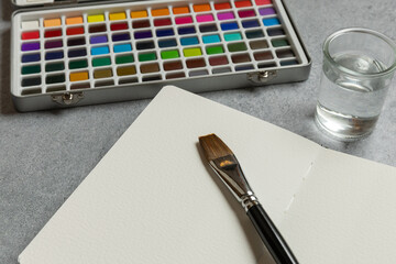 Creative Workspace with Blank Page and Watercolors