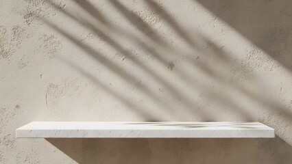 A clean white floating shelf is elegantly positioned on a textured beige wall under the soft, artistic shadows of tropical leaves.
