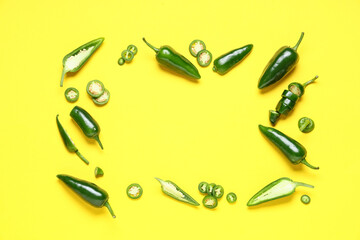Frame made of green jalapeno peppers on yellow background
