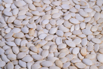 Cozy autumn treat ingredients with warm rustic pumpkin seeds, Arrangement of freshly harvested pumpkin seeds showcasing warm tones suitable for seasonal culinary uses and baking