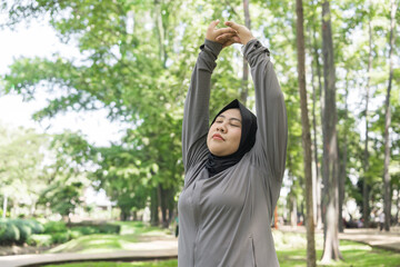 Woman in Hijab Stretching Exercise in Park Outdoors for Fitness, Wellness, and Mindful Living