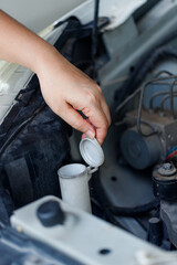 Close up of a hand of woman is checking a liquid coolant pot