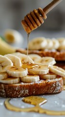 Honey Banana Toast: A close-up slice of artisan toast, with fresh banana slices and drizzled with golden honey