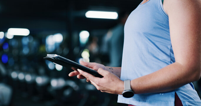 Woman, hands and scroll in gym with tablet, workout research and sign up for personal trainer program. Bokeh, person and digital tech with exercise website, internet and registration for fitness app.