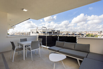 Naklejka premium Spacious terrace with outdoor seating and city view in modern apartment complex