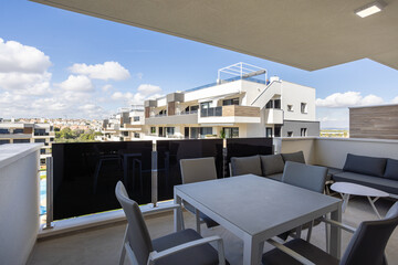 Naklejka premium Modern apartment terrace with gray furniture and scenic city views
