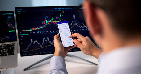 Young Hispanic Businessman Using Mobile App To Trade