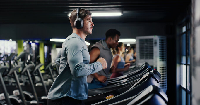 Fitness, running or man with headphones on treadmill in gym, streaming music or cardio workout for health. Performance, exercise machine or athlete with audio tech to listen, training album or active