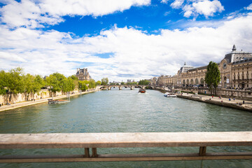 Obraz premium View of Seine River with buildings along the bank and boats sailing on a sunny day in Paris