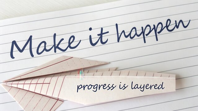 Paper folded in layers spelling Make It Happen with progress