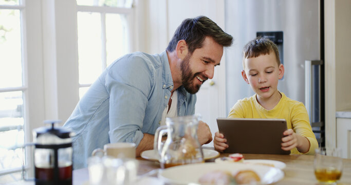 Tablet, child and father in home with smile for app, bonding together and watch show with family. Boy, dad and tech in house for website, online movie or streaming cartoon with parent at breakfast