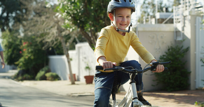 Road, happy and child on bicycle in neighborhood for learning, adventure and cycling outdoor. Smile, weekend and boy on bike with safety gear for ride, fun hobby and active on holiday or vacation