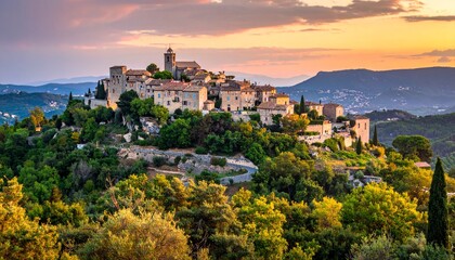 Obraz premium Picturesque hilltop village bathed in the warm glow of a sunset, overlooking the scenic landscape.