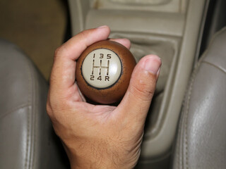 Hand holding manual car gear shifter