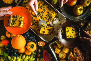 Cozy Autumn Harvest Dinner Party – Hands Sharing Pumpkin Casserole with Seasonal Fruits, Corn, Grapes and Baked Dishes on Rustic Table, Warm Thanksgiving Style Family Feast