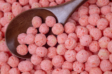 Pink corn breakfast balls and spoon close-up