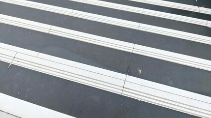 Obraz premium Close up zebra crossing road markings with white lines on dark asphalt. Perfect for traffic safety, transportation, urban life, background design, education, and editorial content. Ideal for designers