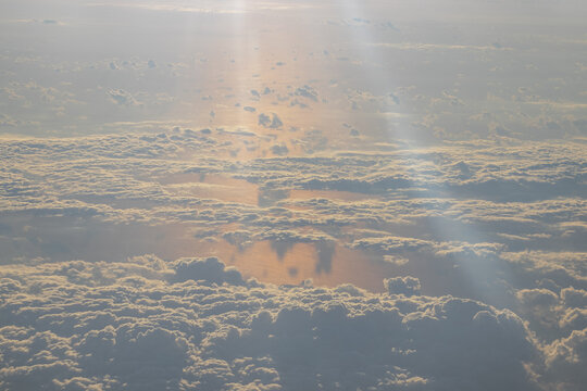 Golden hour cloudscape with soft sunbeams at high altitude