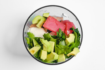 Fresh ingredients prepared for a healthy smoothie in a blender on a white background