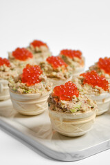 Tuna tartlets with red caviar served on a white platter for a stylish appetizer display