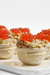Delicious tuna tartlets topped with bright red caviar served at a stylish gathering