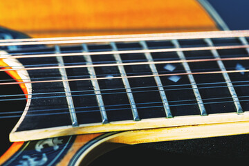 Obraz premium Twelve strings guitar fretboard with metal strings, ornate inlays, and decorative wood grain near the sound hole. Craftsmanship and texture highlight musical artistry and fine detail