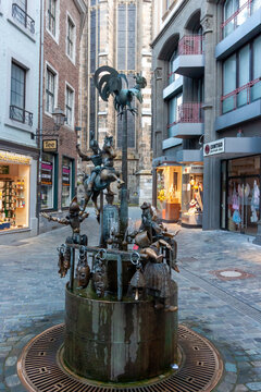 Bronze Puppet Fountain (Puppenbrunnen) in the old town of Aachen, Germany. Iconic landmark featuring movable figures near the Cathedral in a pedestrian zone