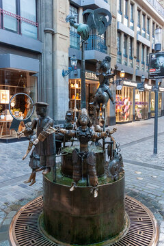 Bronze Puppet Fountain (Puppenbrunnen) in the old town of Aachen, Germany. Iconic landmark featuring movable figures near the Cathedral in a pedestrian zone