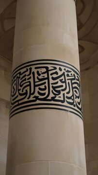 Calligraphy on a Minaret Shaft. Islamic Culture &ndash; Building and Architecture. Smooth minaret shaft where a wide band of striking black Thuluth script calligraphy wraps around the stone structure.
