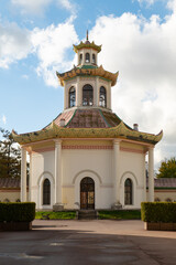 Obraz premium A small Chinese church against a backdrop of blue sky and clouds