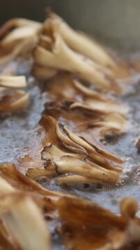 Hen of the Woods or Maitake Mushroom are Fried in Boiling Oil. Close-up view