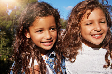 Fototapeta premium Thinking, children and siblings with smile outdoor for love, reflection and bonding on holiday. Happy, kids and sisters embrace with care, family connection and daydreaming with affection on vacation