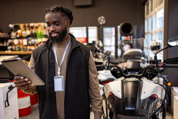 Fototapeta premium Motorcycle equipment salesman holding a tablet