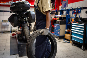 Fototapeta premium Young man repairing motocross bike in repair shop