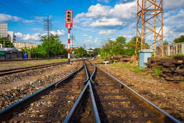 railway traffic light at an old transfer point with power lines and wooden tracks as a backdrop.