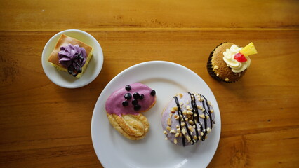 a cupcake on a white plate on a wooden table, breakfast menu in the morning, with natural lighting in the morning