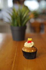 a cupcake on a white plate on a wooden table, breakfast menu in the morning, with natural lighting in the morning