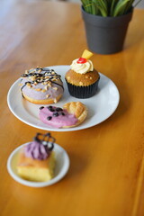 a cupcake on a white plate on a wooden table, breakfast menu in the morning, with natural lighting in the morning
