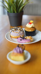 a cupcake on a white plate on a wooden table, breakfast menu in the morning, with natural lighting in the morning
