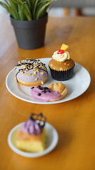a cupcake on a white plate on a wooden table, breakfast menu in the morning, with natural lighting in the morning