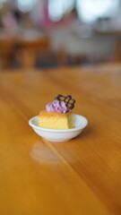 a cupcake on a white plate on a wooden table, breakfast menu in the morning, with natural lighting in the morning