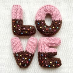 Colorful knitted letters spelling love with sprinkles on top